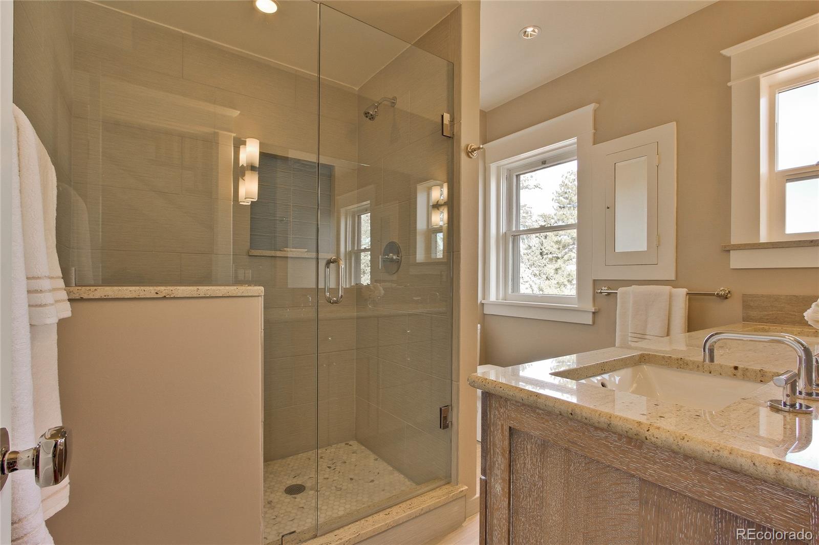 935 10th Street Boulder, CO 80302 - Photo 24 of 40 a bathroom with a granite countertop shower mirror and a sink
