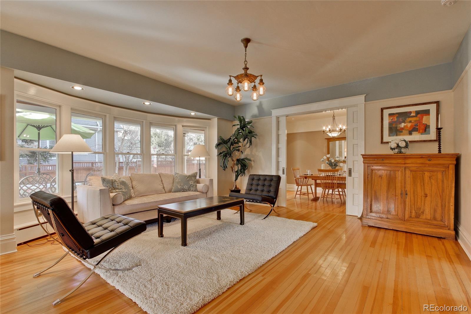 935 10th Street Boulder, CO 80302 - Photo 7 of 40 a living room with furniture a dining table wooden floor and a chandelier