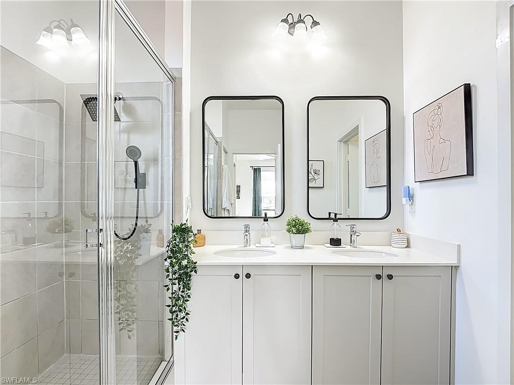 5502 Cassidy Lane Immokalee, FL 34142 - Photo 18 of 20 a bathroom with a double vanity sink mirror and shower