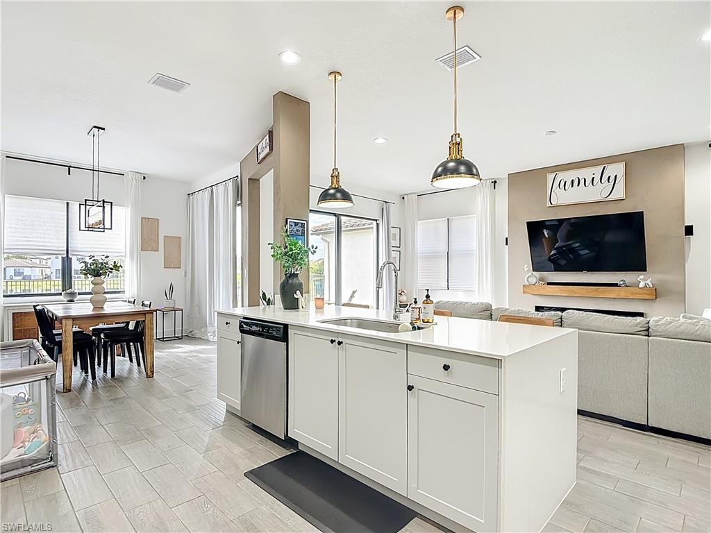 5502 Cassidy Lane Immokalee, FL 34142 - Photo 9 of 20 a kitchen with counter top space sink dining table and stainless steel appliances