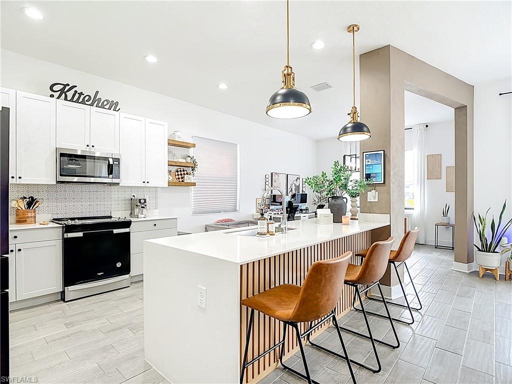 5502 Cassidy Lane Immokalee, FL 34142 - Photo 10 of 20 a kitchen with stainless steel appliances kitchen island granite countertop a sink and cabinets