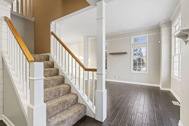 a kitchen with stainless steel appliances granite countertop a refrigerator a stove a sink and white cabinets with wooden floor