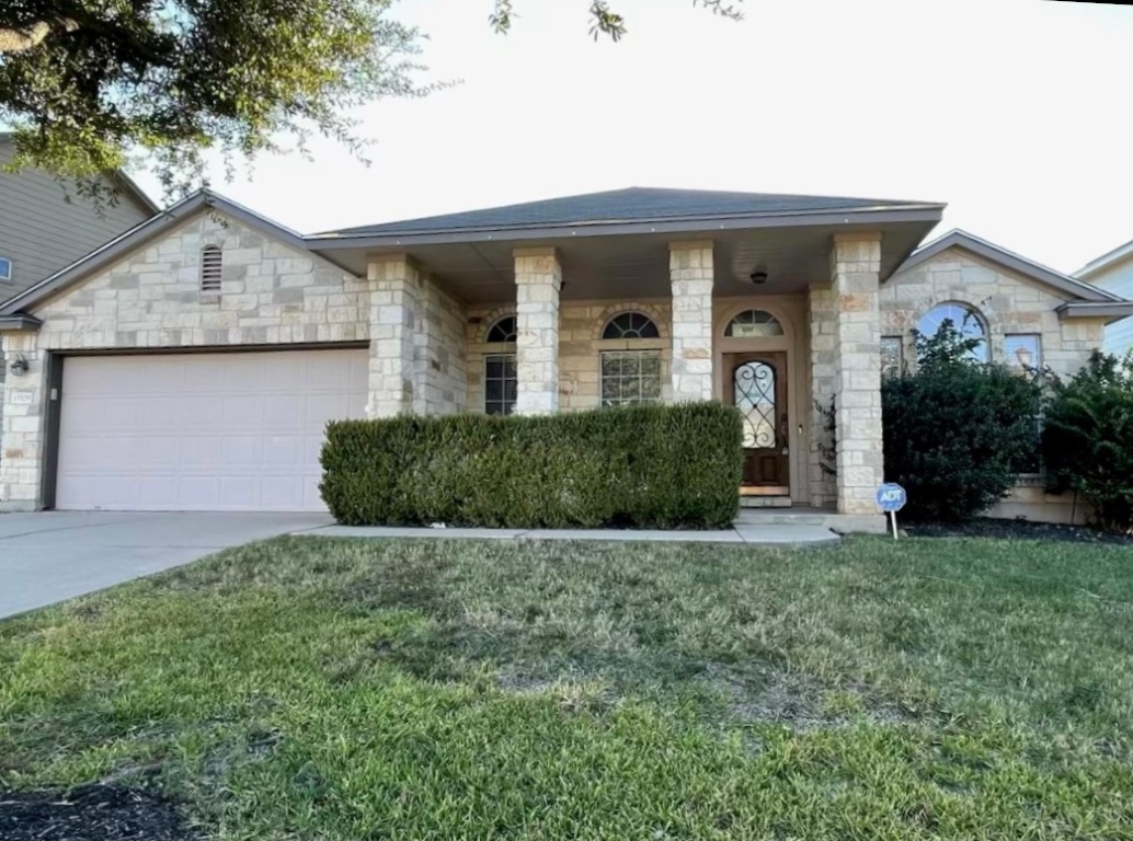 15529 Staked Plains Loop Austin, TX 78717 - Photo 1 of 32 View of front of property featuring a front lawn, stone siding, an attached garage, and concrete driveway