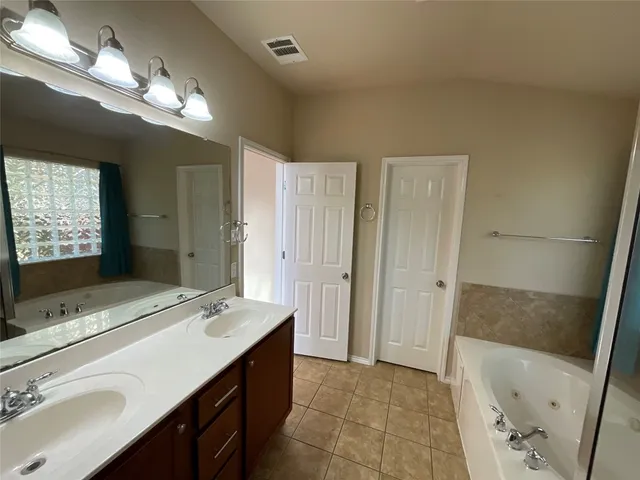 a bathroom with a sink a large mirror and a bathtub