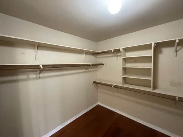 a view of walk in closet with empty racks