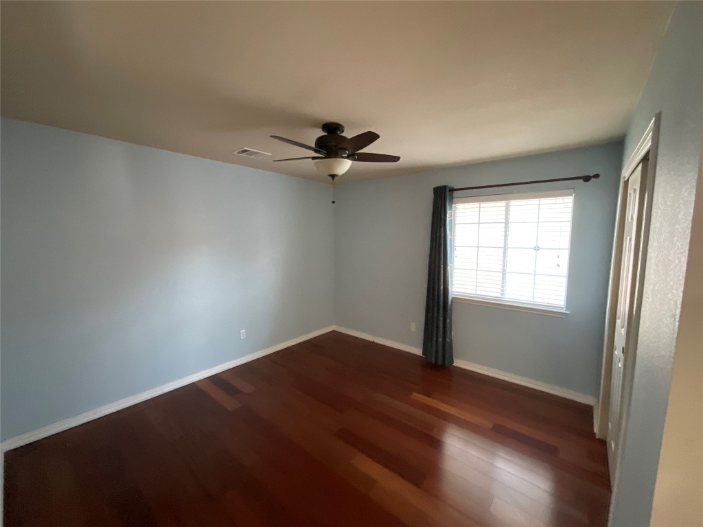 15529 Staked Plains Loop Austin, TX 78717 - Photo 22 of 32 Unfurnished bedroom with dark wood-type flooring, ceiling fan, and a closet