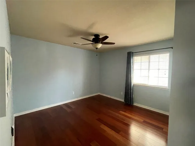 an empty room with a window and a ceiling fan