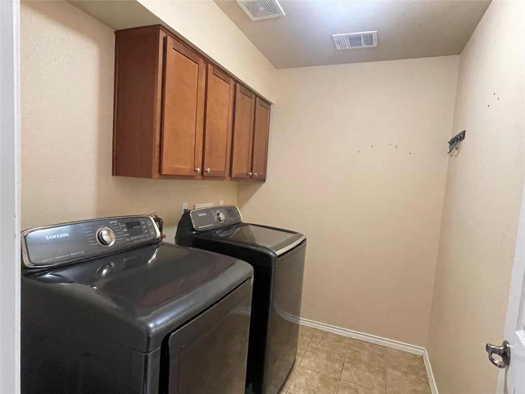 15529 Staked Plains Loop Austin, TX 78717 - Photo 25 of 32 Laundry room with cabinet space, separate washer and dryer, and light tile patterned floors