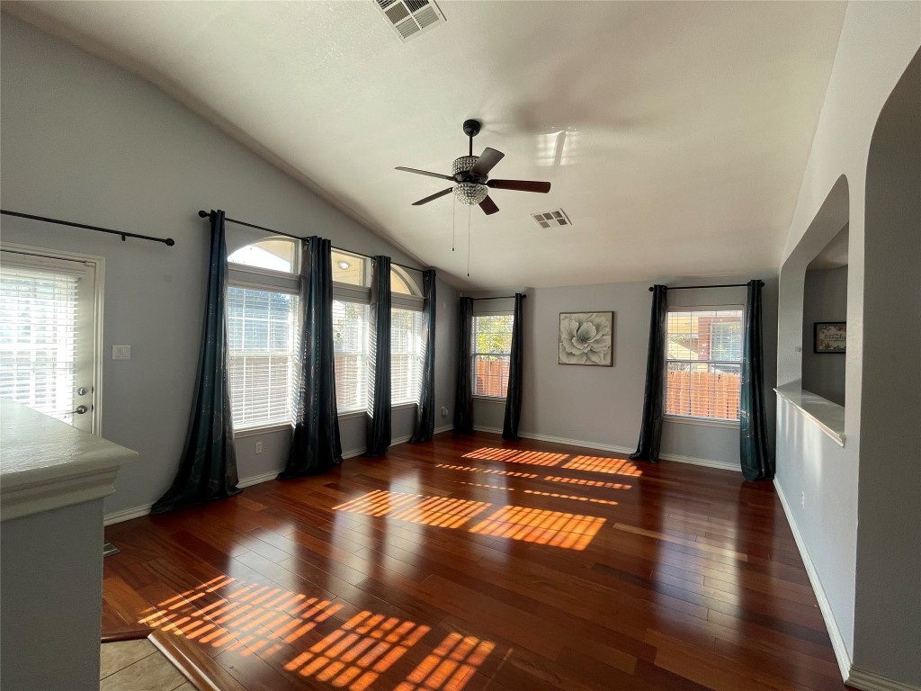 15529 Staked Plains Loop Austin, TX 78717 - Photo 4 of 32 Empty room featuring lofted ceiling, wood-type flooring, ceiling fan, and arched walkways