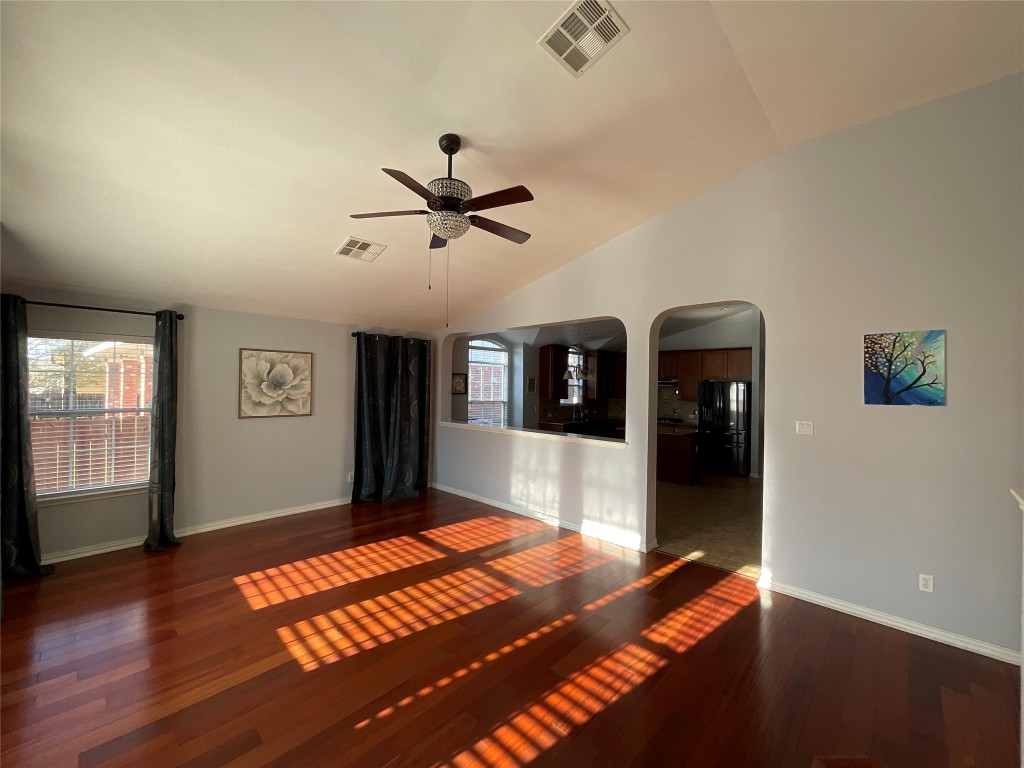 15529 Staked Plains Loop Austin, TX 78717 - Photo 7 of 32 Spare room with vaulted ceiling, dark wood-style floors, arched walkways, and a ceiling fan