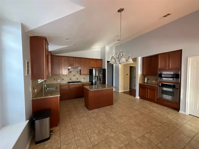 a large living room with stainless steel appliances kitchen island granite countertop furniture and a view of kitchen