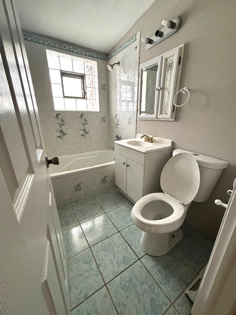 66 East Blecke Avenue, Unit 66 Addison, IL 60101 - Photo 11 of 14 a spacious bathroom with a toilet sink a mirror a bathtub and next to a window