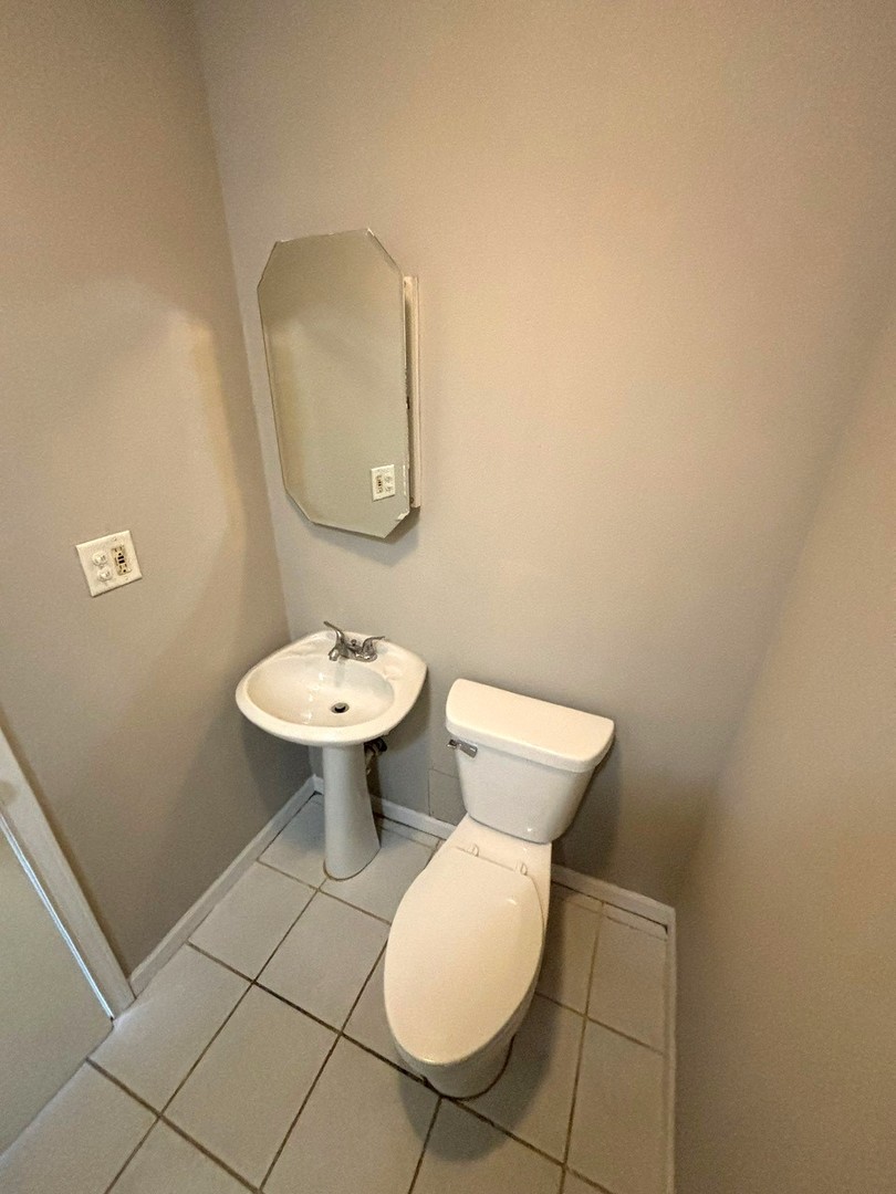 66 East Blecke Avenue, Unit 66 Addison, IL 60101 - Photo 7 of 14 a bathroom with a toilet sink and mirror
