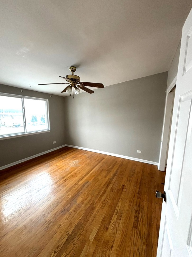 66 East Blecke Avenue, Unit 66 Addison, IL 60101 - Photo 9 of 14 wooden floor in an empty room with a window