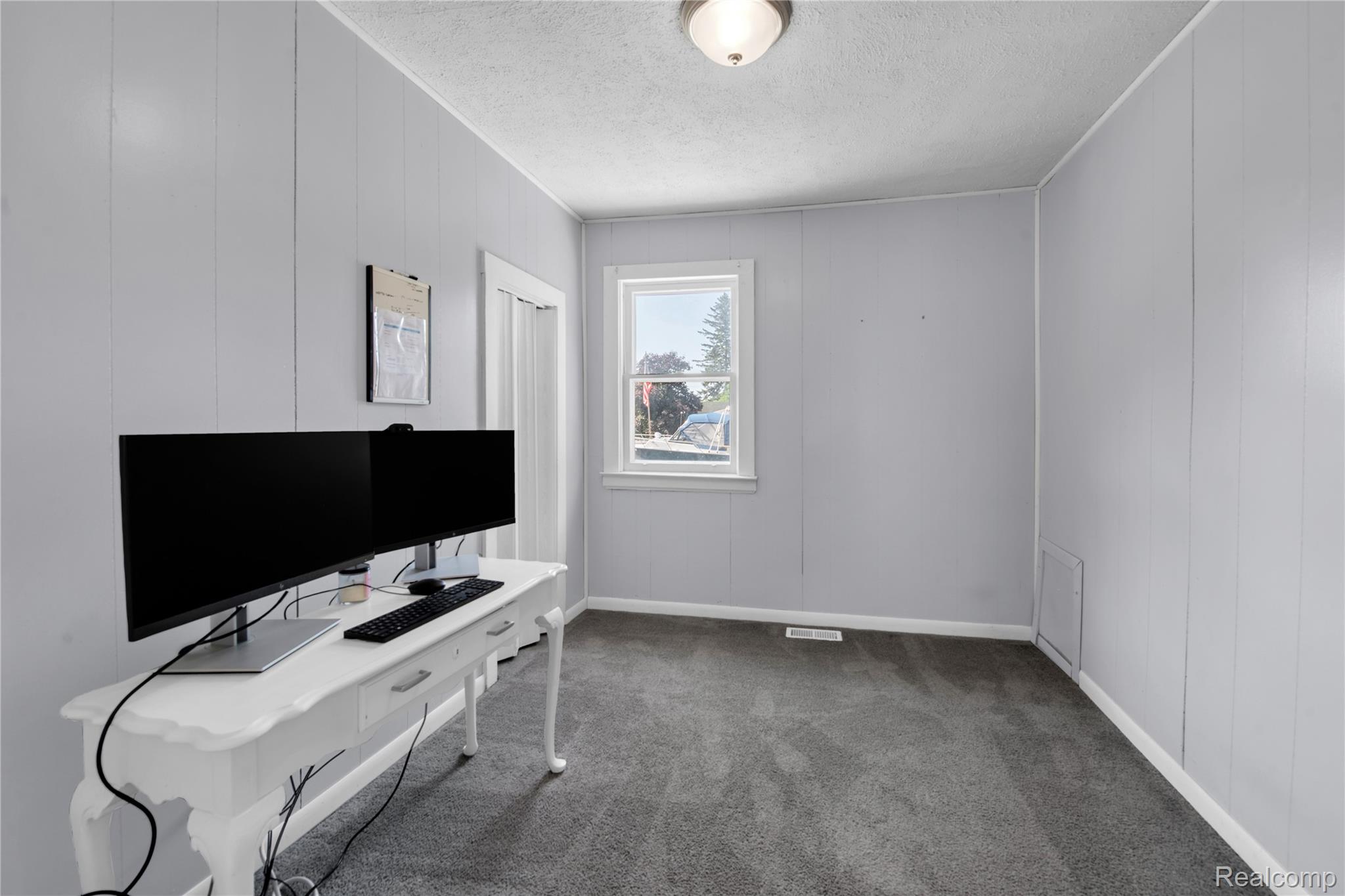 58925 Haven Ridge Road New Haven, MI 48048 - Photo 11 of 22 Carpeted home office with a textured ceiling and wood walls