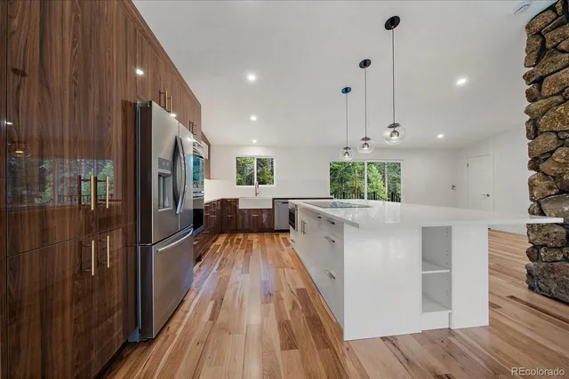 a kitchen with stainless steel appliances kitchen island sink refrigerator and stove