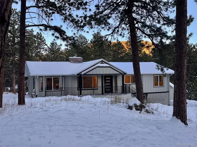 a front view of a house with a yard covered in snow