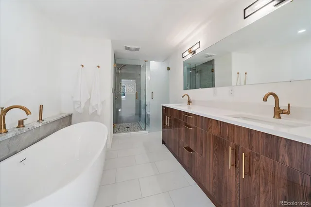 a spacious bathroom with a double vanity sink mirror and bathtub