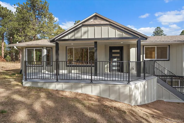 a view of a house with a small yard and wooden floor and fence