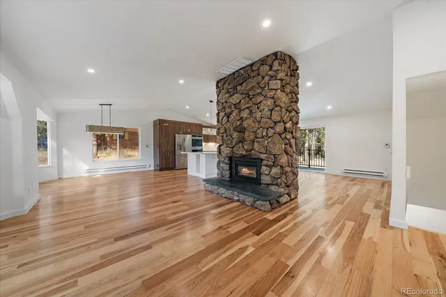 a view of a livingroom with wooden floor and a fireplace