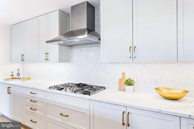 a large white kitchen with stainless steel appliances