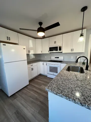 a kitchen with kitchen island a white counter top space cabinets and stainless steel appliances