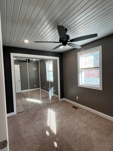 a view of a livingroom with a ceiling fan and window
