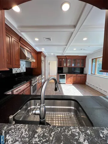a kitchen with stainless steel appliances granite countertop a sink a stove counter space and cabinets