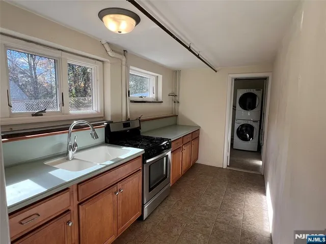a kitchen with stainless steel appliances granite countertop a sink and a stove next to a window