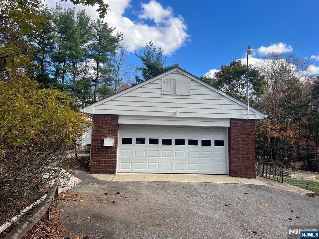 391 Forest Road Mahwah, NJ 07430 - Photo 4 of 32 a front view of a house with a yard and garage