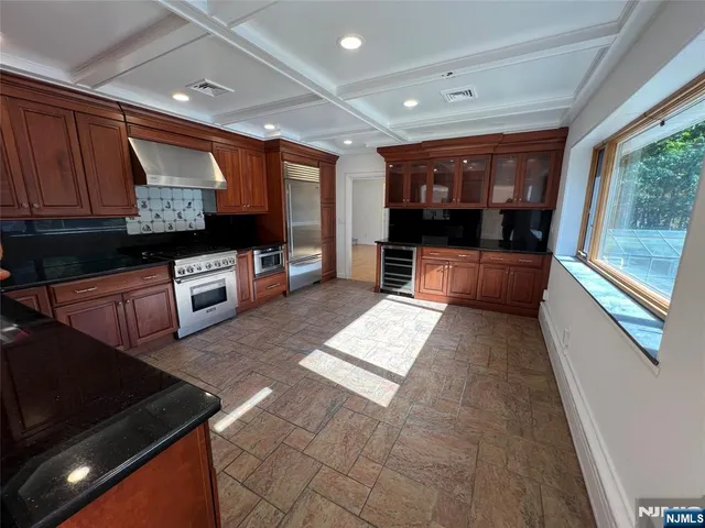 a large kitchen with stainless steel appliances wooden cabinets and a granite counter tops