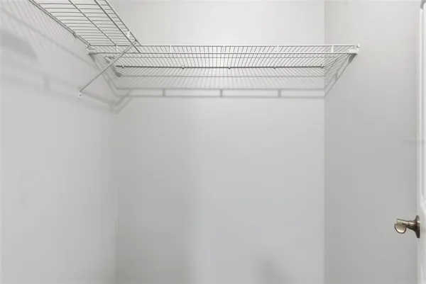 an empty room with wooden floor ceiling fan and windows