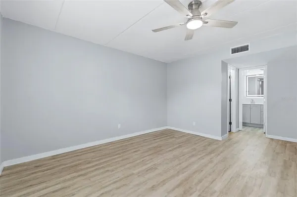 a view of an empty room with wooden floor