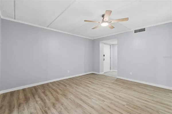 a view of an empty room with wooden floor