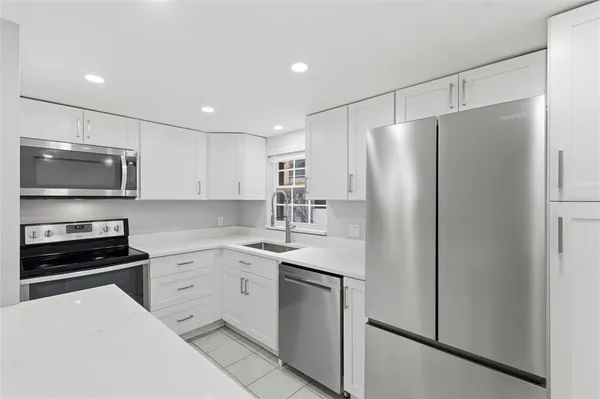 a kitchen with white cabinets and stainless steel appliances