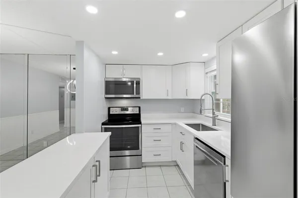 a kitchen with stainless steel appliances granite countertop a refrigerator and a sink