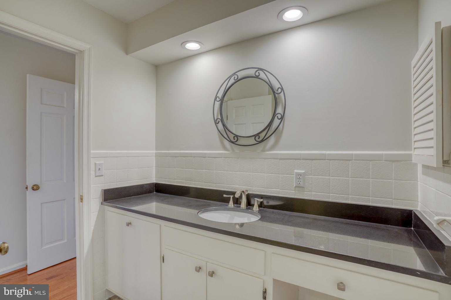5 Stuart Drive Dover, DE 19901 - Photo 33 of 64 a bathroom with a granite countertop sink a mirror and vanity