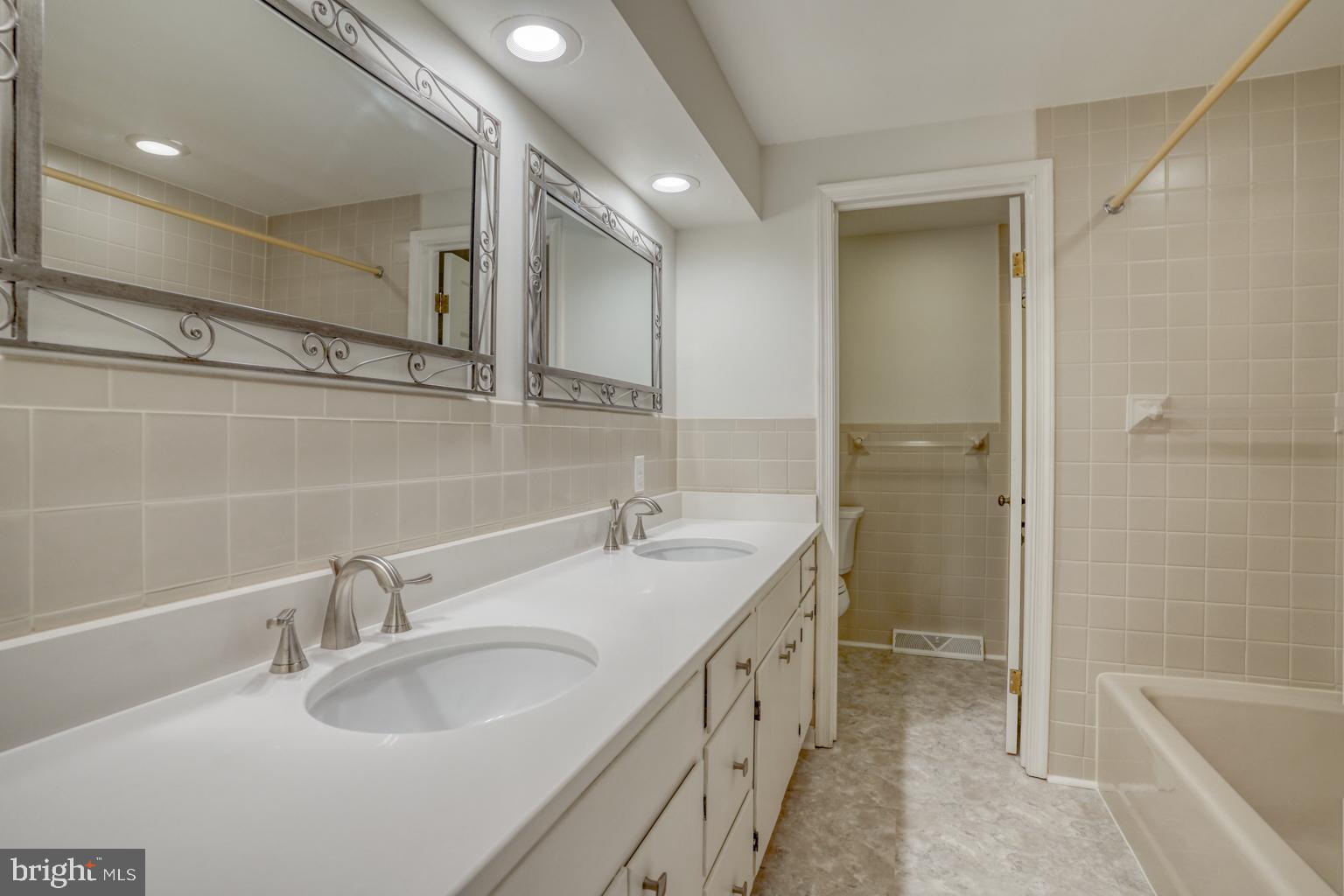 5 Stuart Drive Dover, DE 19901 - Photo 46 of 64 a bathroom with a sink double vanity granite tub shower and a mirror