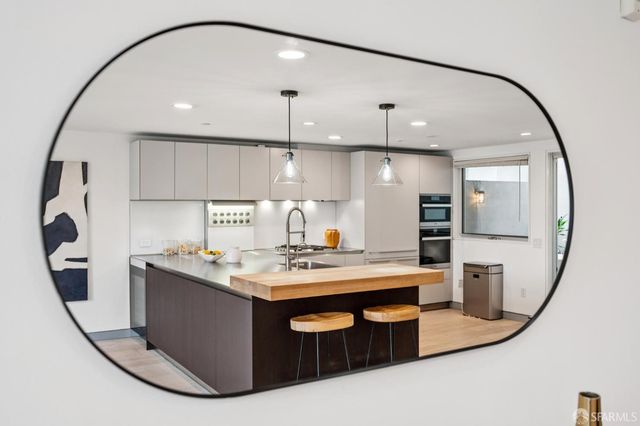 a kitchen with stainless steel appliances granite countertop a sink a stove and a wooden floor