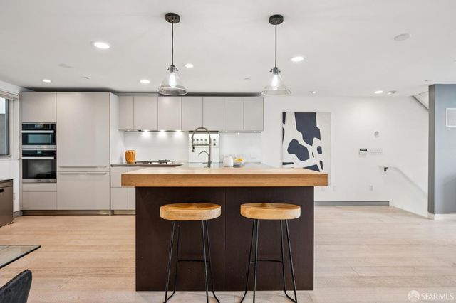 a kitchen with kitchen island a sink stainless steel appliances and cabinets