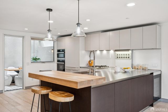 a kitchen with stainless steel appliances a sink a counter space and a center island