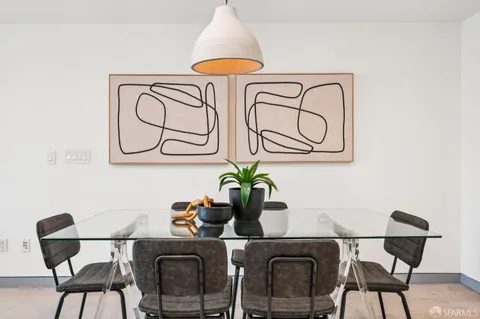 a table with a vase and flowers on it with a dining table chair