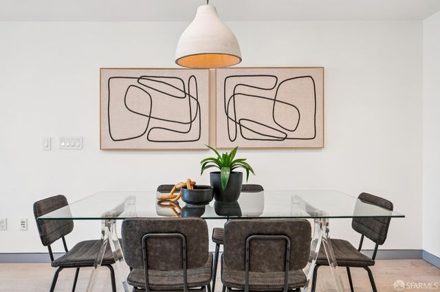 a table with a vase and flowers on it with a dining table chair