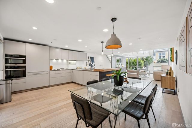 a kitchen with stainless steel appliances kitchen island granite countertop a kitchen island a stove a table and chairs