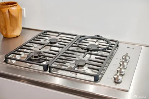 a kitchen with stainless steel appliances kitchen island granite countertop a sink and a refrigerator