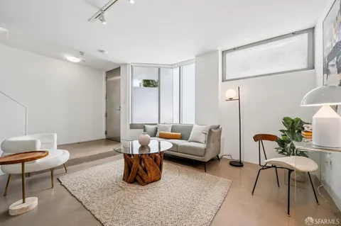 a spacious bedroom with a bed a table and chairs