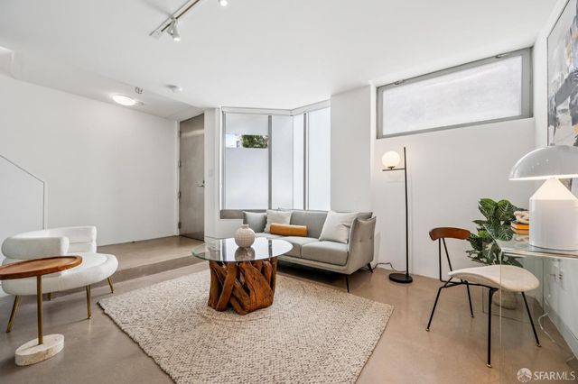 a spacious bedroom with a bed a table and chairs
