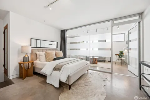 a bedroom with a bed and a large mirror