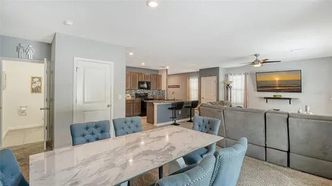 a kitchen with stainless steel appliances kitchen island granite countertop a refrigerator a stove a microwave oven a sink with island and chairs