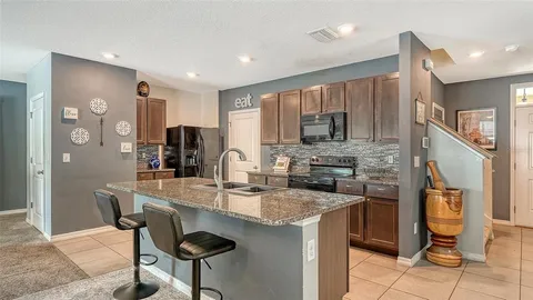 a kitchen with stainless steel appliances granite countertop a stove a sink a refrigerator and a microwave